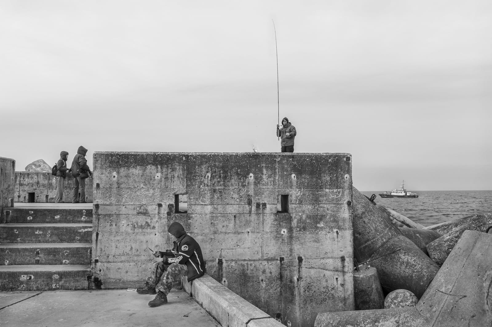 Рыбаки на побережье морской границы России. Катера пограничной службы (справа). Фото Олега Климова